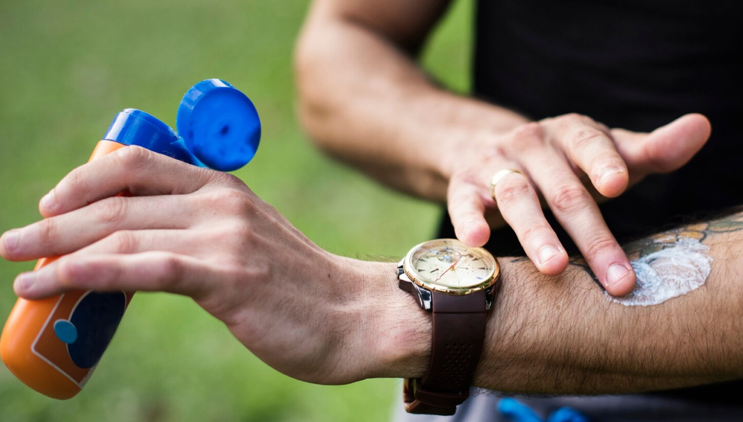 hombre colocando bloqueador solar sobre su brazo